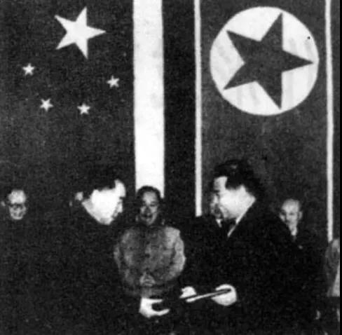 △周恩來(lái)和金日成在簽字后互換議定書(shū)。.jpg